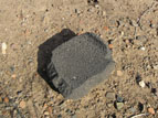 Broken matate, surrounded by pot sherds.